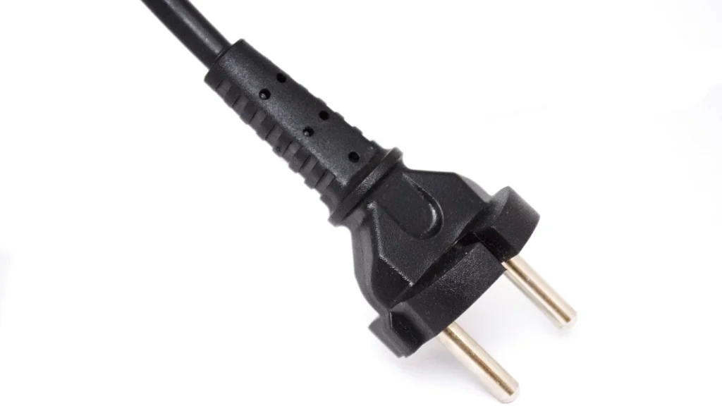 Electrical cable and plug on a plain background