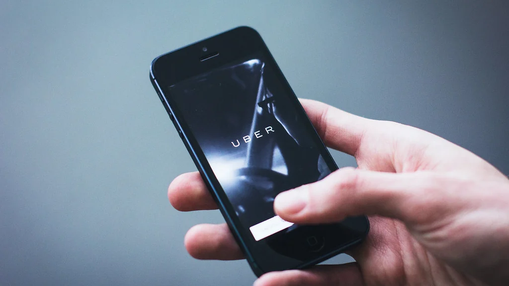Hand holding a phone showing an app screen