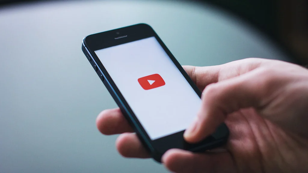 Hand holding a phone showing an app screen
