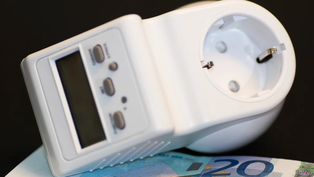 Plug-in energy meter resting on banknotes, showing what an appliance costs to run