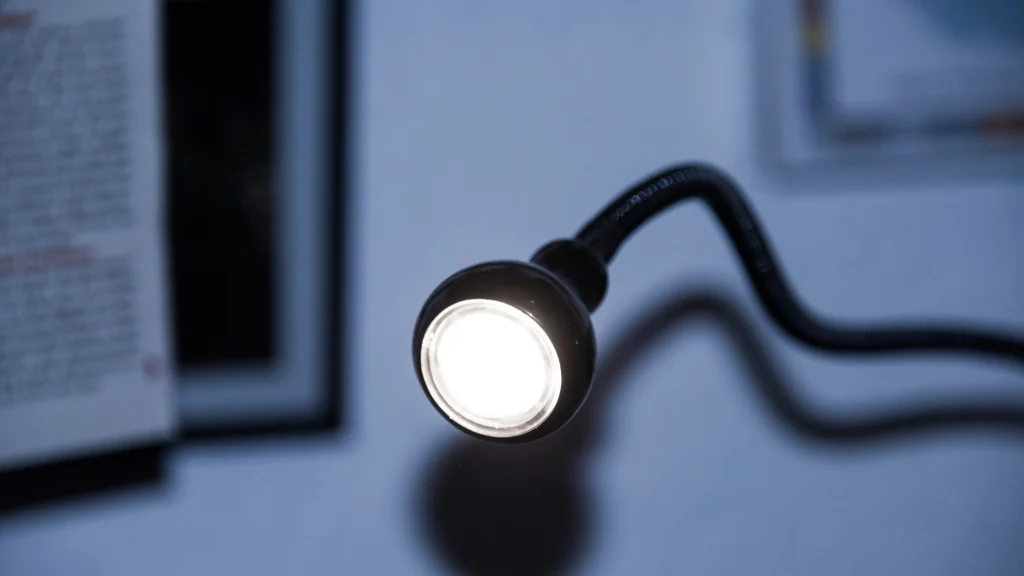 Reading lamp switched on beside a desk