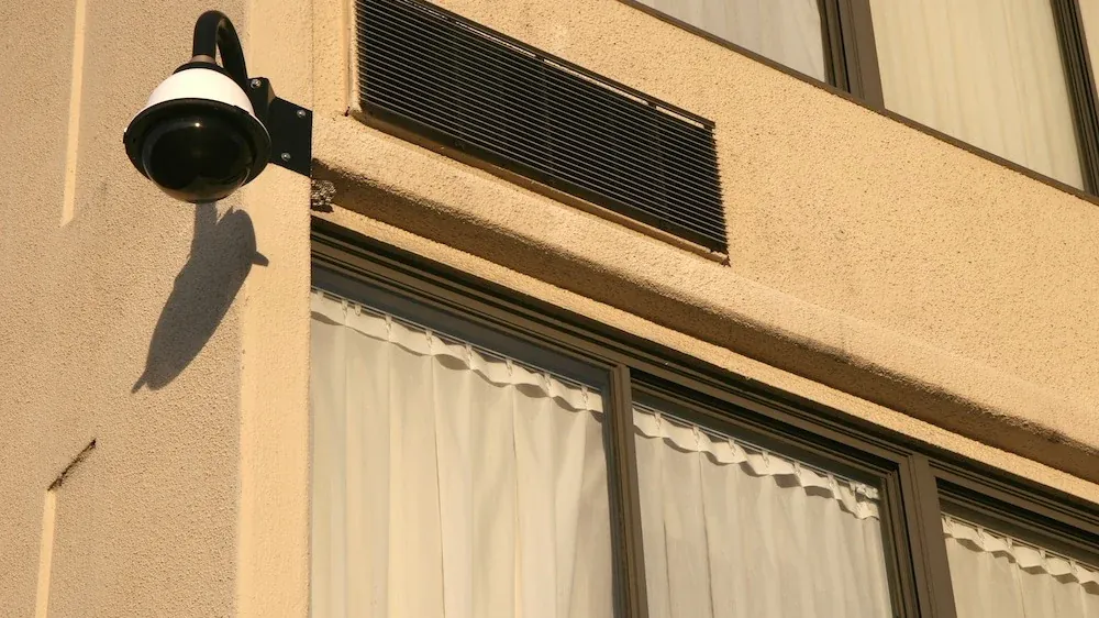 Security camera mounted high on an outside wall