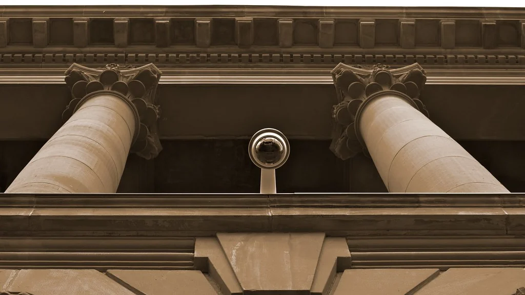 Small security camera fixed beneath a ceiling