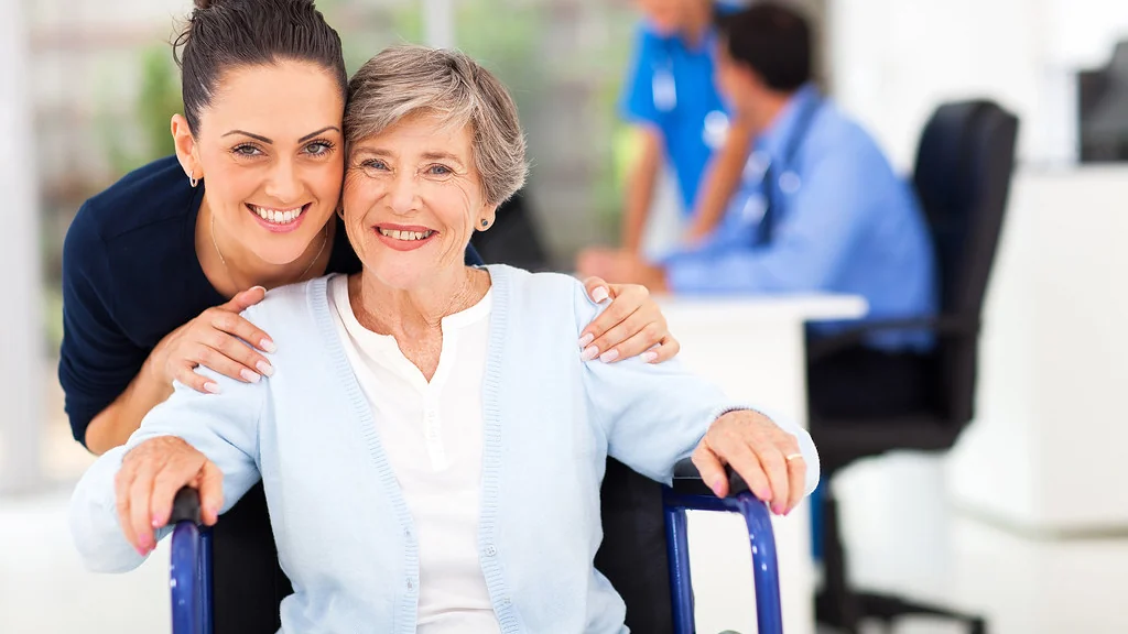 Two women smiling together in a bright room