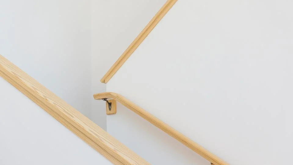 Wooden handrail fixed along a wall